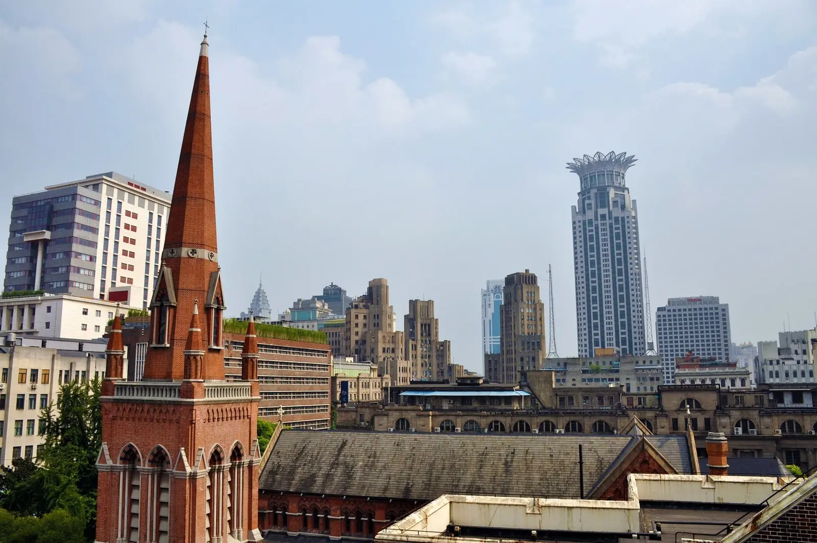 Holy Trinity Cathedral in Shanghai, with its red-brick spire and long church roof against the city skyline.