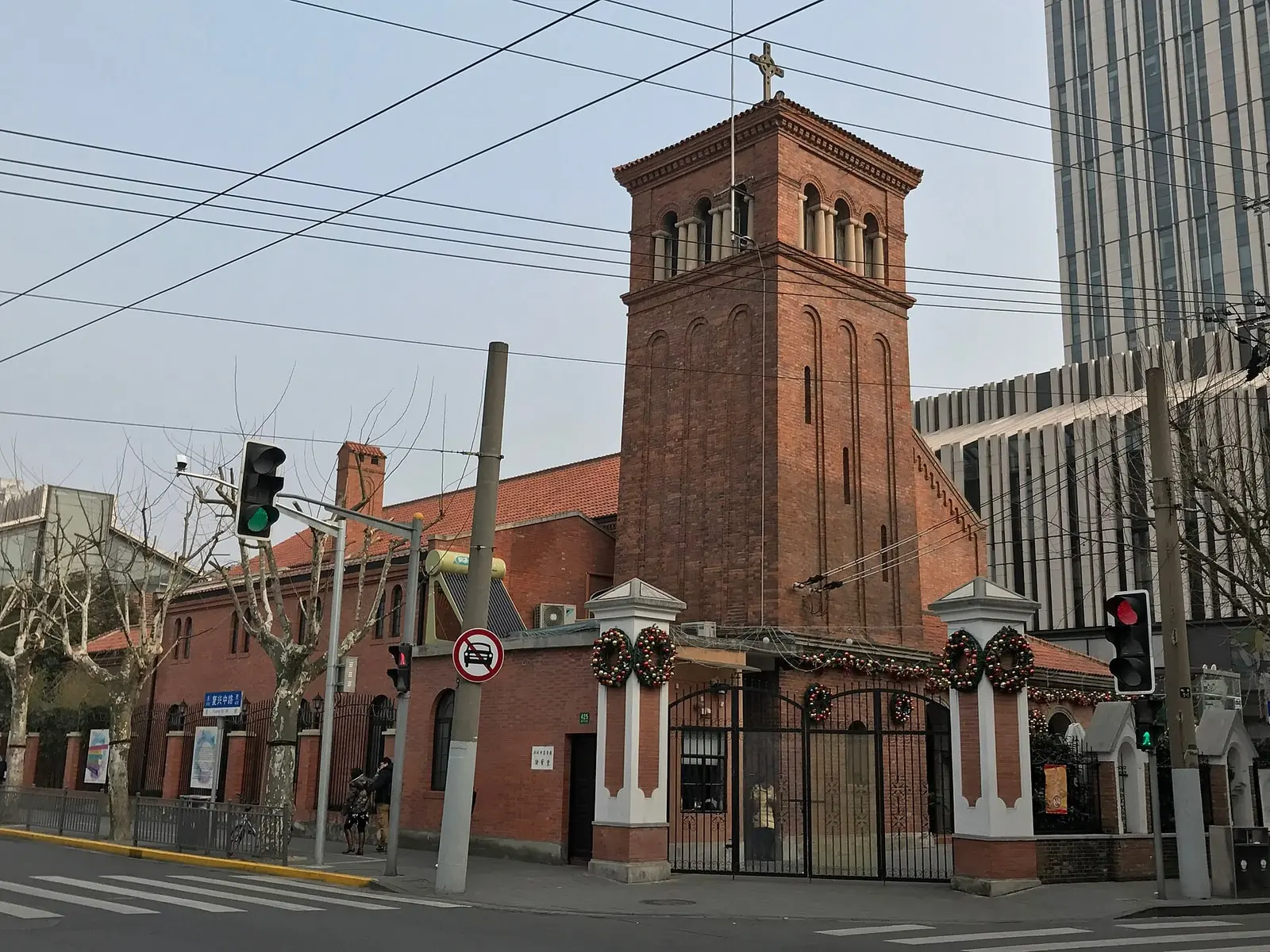 All Saints Church on a street corner, with its brick bell tower and red boundary wall.