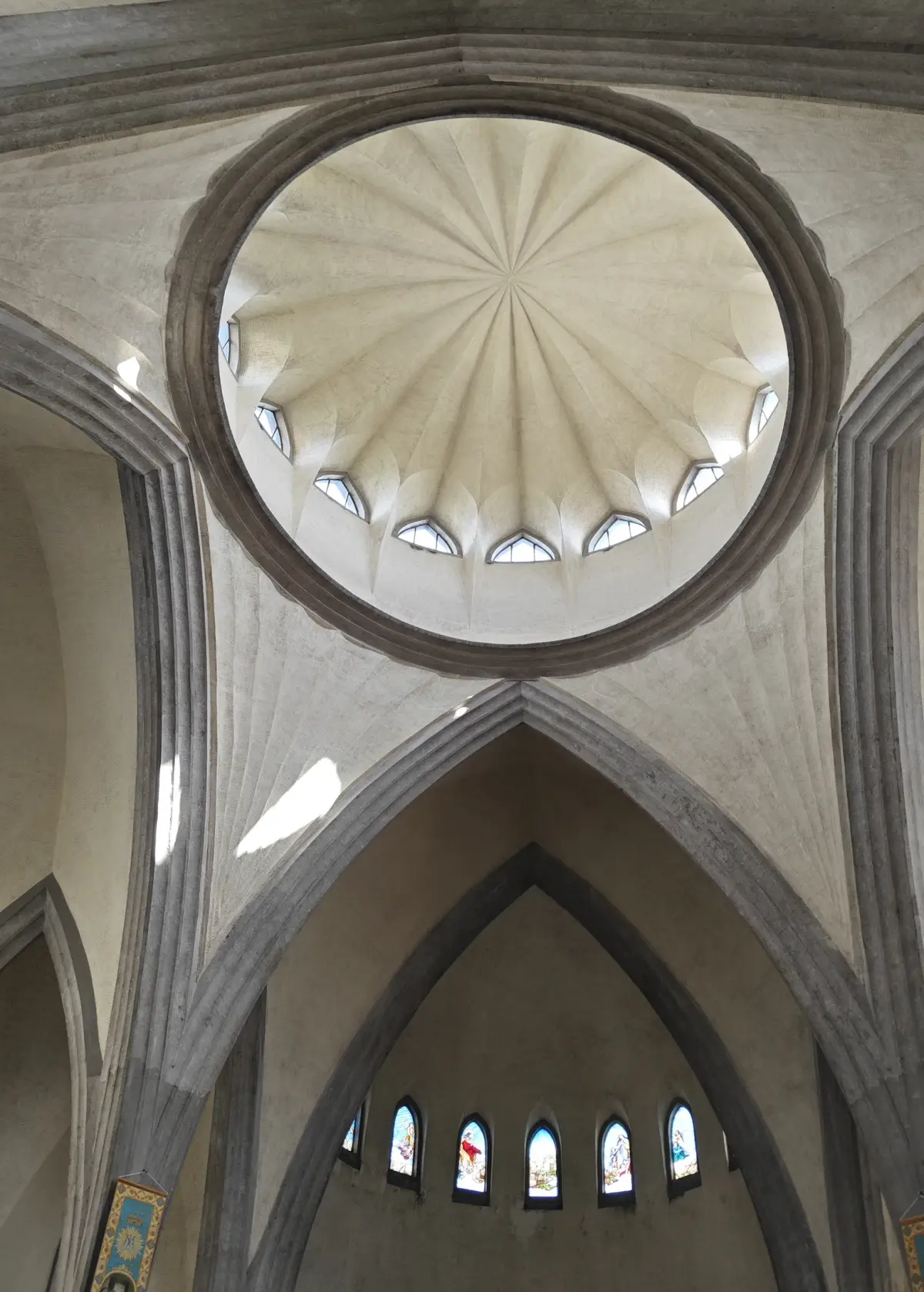 The interior of a ribbed white dome seen from below, surrounded by arches.