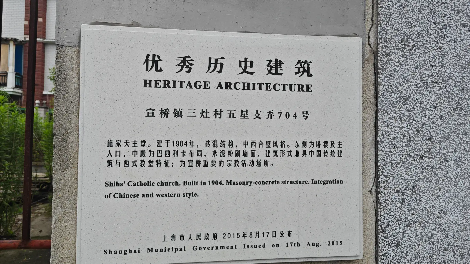 A white stone plaque reading Heritage Architecture in Chinese and English, with a short description of the church.